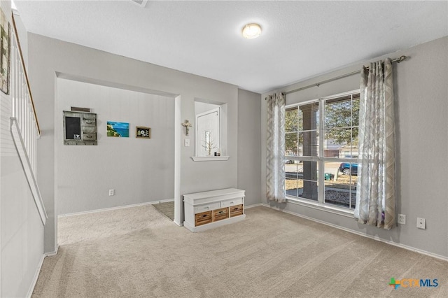 unfurnished room with carpet and baseboards