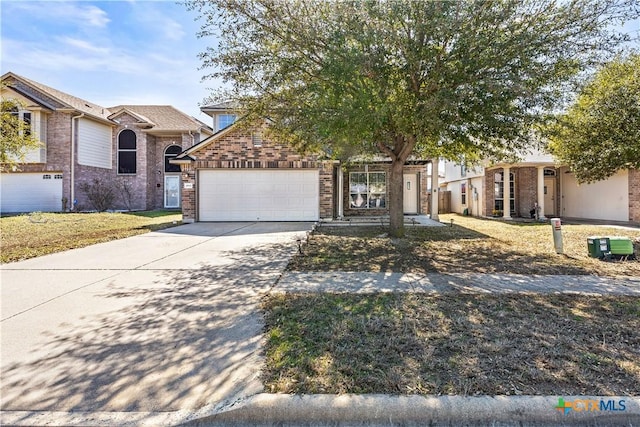 view of property hidden behind natural elements with a garage, concrete driveway, brick siding, and a front lawn