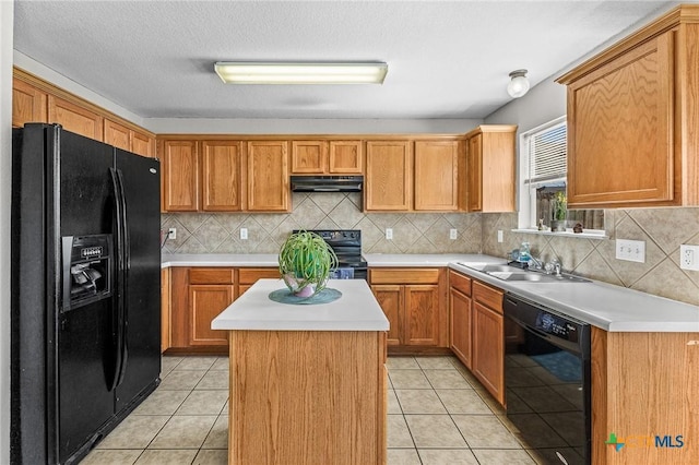 kitchen with black appliances, under cabinet range hood, light countertops, and a sink