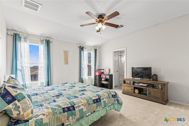 carpeted bedroom featuring multiple windows, visible vents, vaulted ceiling, and a ceiling fan