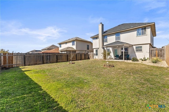 back of house with a yard, a chimney, and a fenced backyard