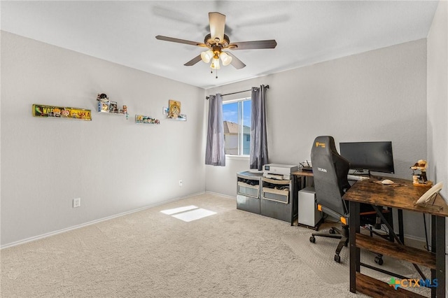 carpeted office with a ceiling fan and baseboards