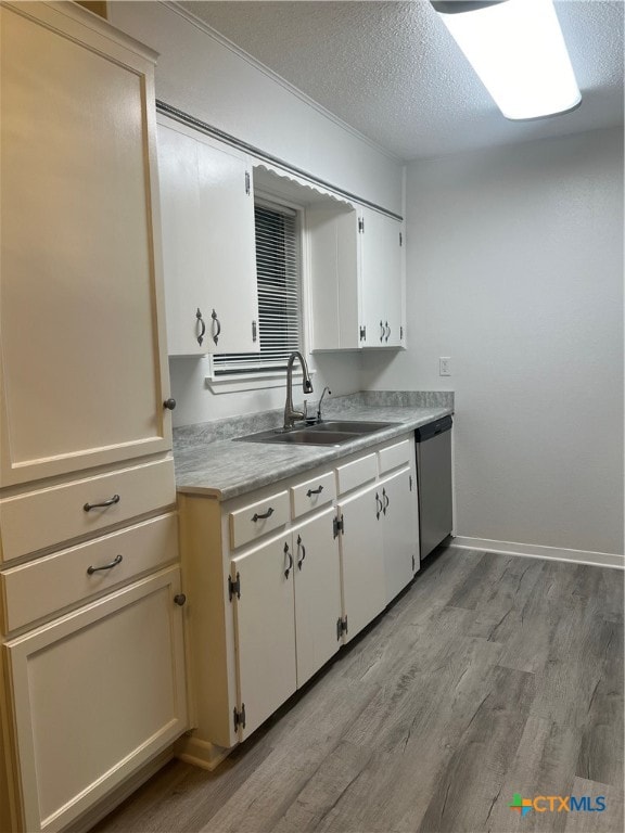 kitchen with white cabinets, light hardwood / wood-style floors, sink, and dishwasher