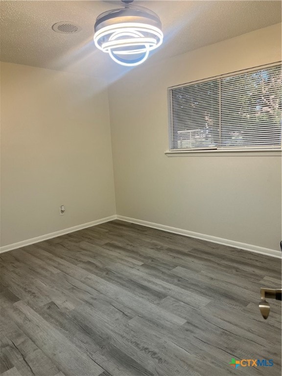 spare room with dark hardwood / wood-style flooring and a textured ceiling