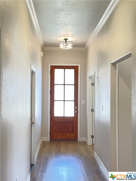 doorway with hardwood / wood-style floors, ornamental molding, and a textured ceiling