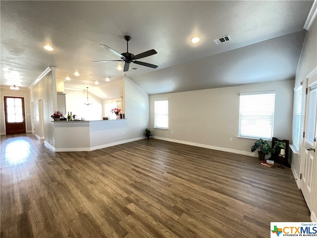 unfurnished living room with a wealth of natural light, dark hardwood / wood-style flooring, lofted ceiling, and ceiling fan