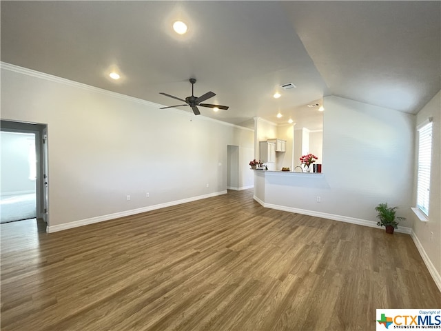 unfurnished living room featuring hardwood / wood-style floors, vaulted ceiling, and ornamental molding