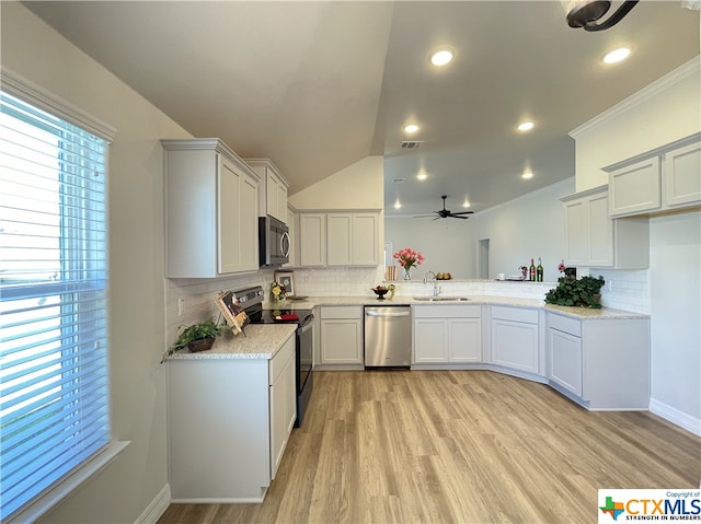 kitchen featuring backsplash, appliances with stainless steel finishes, and light hardwood / wood-style flooring