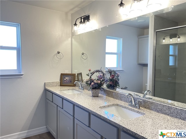 bathroom with vanity and a shower with door