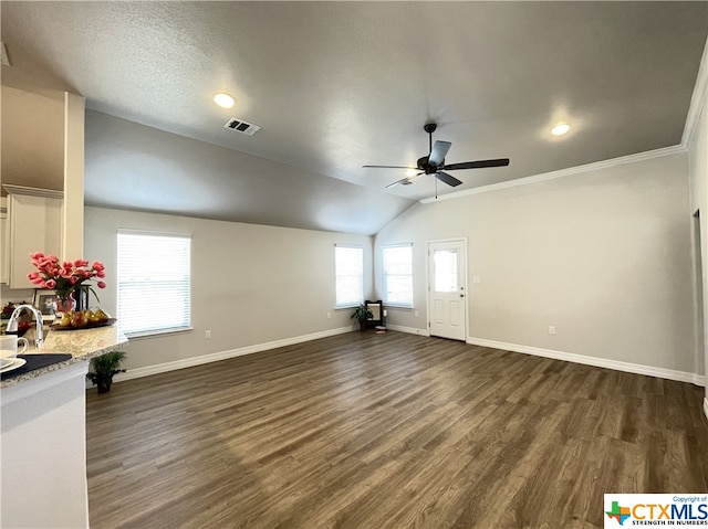 unfurnished living room with crown molding, a textured ceiling, dark hardwood / wood-style flooring, vaulted ceiling, and ceiling fan