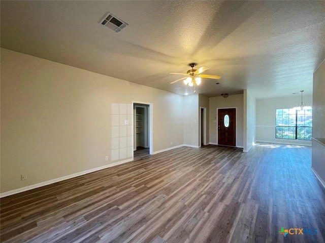 unfurnished living room featuring ceiling fan with notable chandelier, a textured ceiling, and dark hardwood / wood-style floors