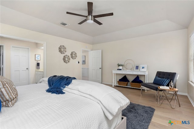 bedroom with light wood-type flooring, visible vents, vaulted ceiling, ceiling fan, and baseboards