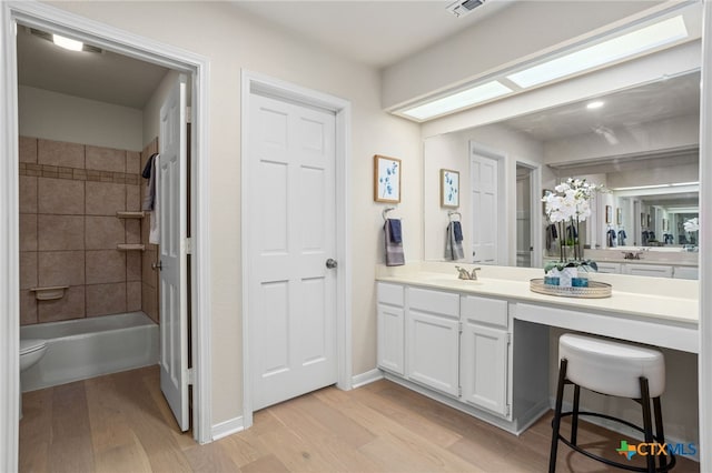 full bathroom with baseboards, vanity, shower / bathing tub combination, and wood finished floors