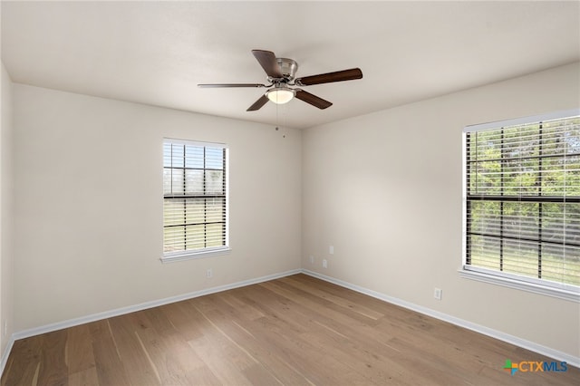 unfurnished room featuring baseboards, ceiling fan, and wood finished floors