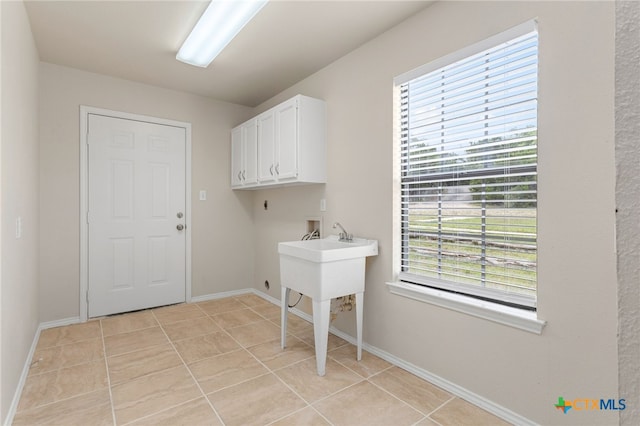 washroom featuring light tile patterned floors, cabinet space, hookup for an electric dryer, hookup for a washing machine, and baseboards