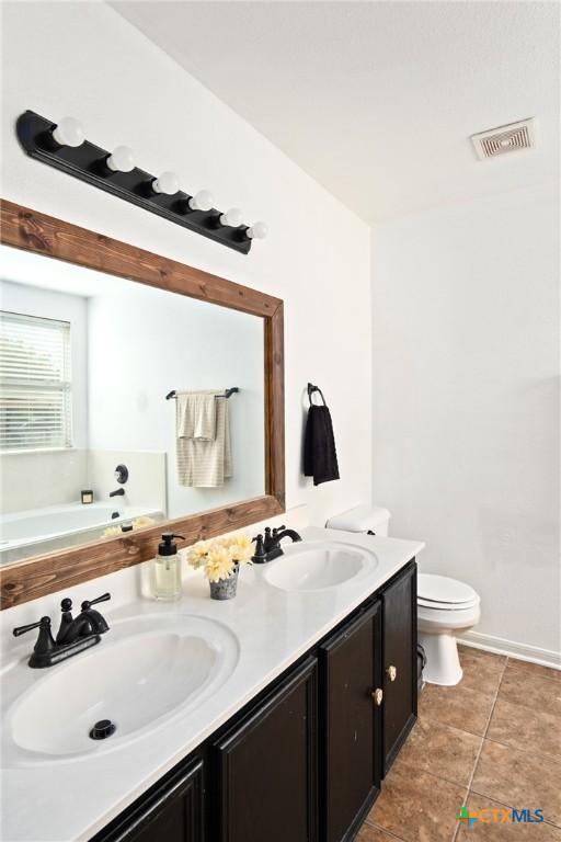 5607 Schorn Dr, Killeen, TX 76542 - full bathroom featuring double vanity, toilet, a bath, and tile patterned flooring