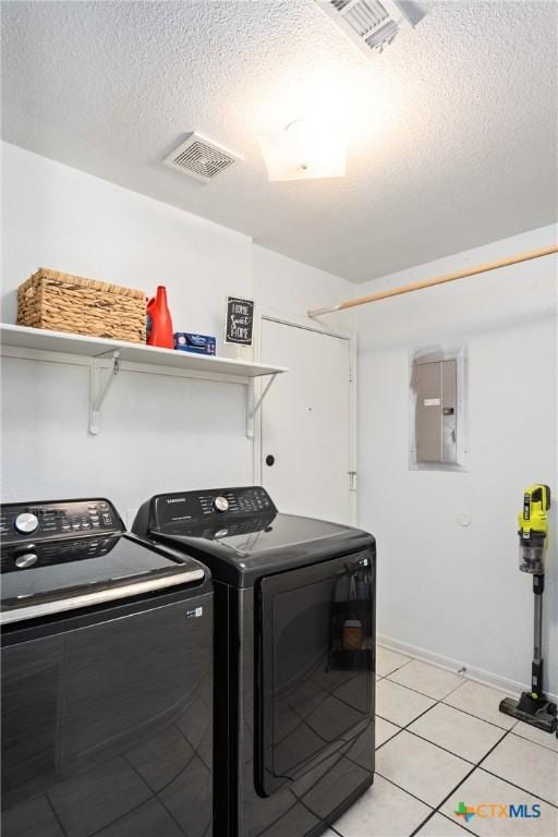5607 Schorn Dr, Killeen, TX 76542 - laundry area with electric panel, washer and dryer, a textured ceiling, light tile patterned floors, and baseboards
