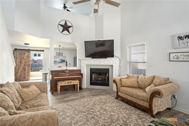 5607 Schorn Dr, Killeen, TX 76542 - living room featuring a towering ceiling, wood finished floors, a ceiling fan, a fireplace, and baseboards