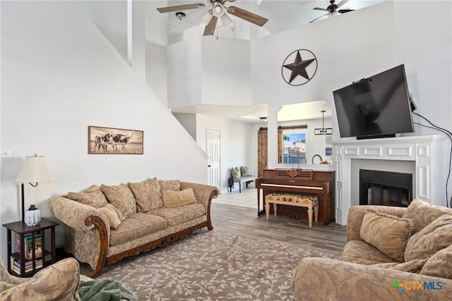 5607 Schorn Dr, Killeen, TX 76542 - living area featuring a ceiling fan, a fireplace, wood finished floors, and a towering ceiling