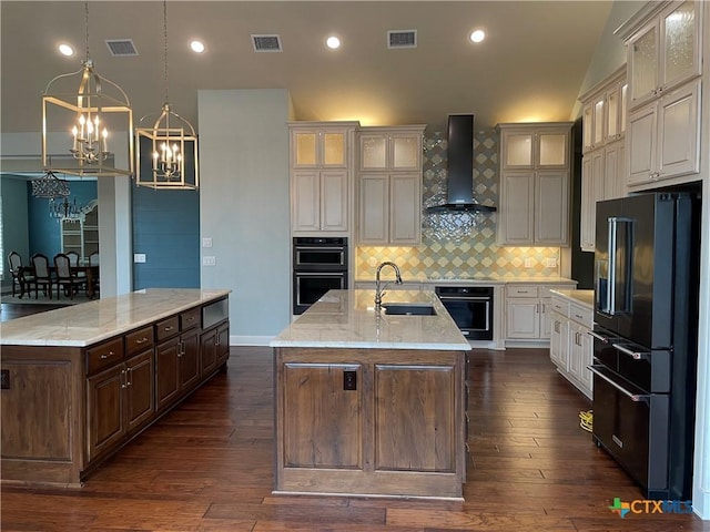 750 Mission Hts, New Braunfels, TX 78130 - kitchen with an island with sink, black appliances, wall chimney exhaust hood, a sink, and a notable chandelier