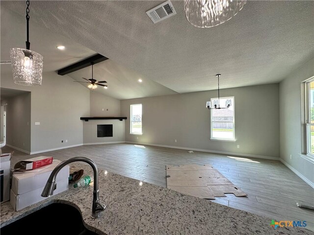 2598 Settlers Oak Dr, Belton, TX 76513 - unfurnished living room featuring wood finished floors, a textured ceiling, ceiling fan, baseboards, and a sink