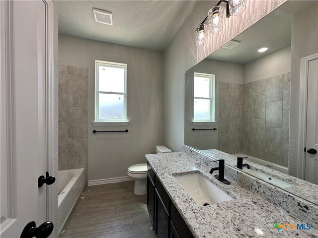 2598 Settlers Oak Dr, Belton, TX 76513 - bathroom with toilet, vanity, wood finished floors, baseboards, and bathing tub / shower combination