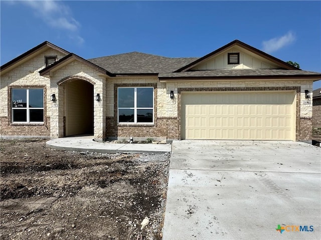 2598 Settlers Oak Dr, Belton, TX 76513 - view of front of house featuring an attached garage, brick siding, concrete driveway, stone siding, and a shingled roof