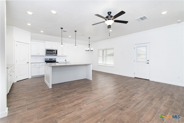 kitchen with stainless steel appliances, a kitchen island with sink, wood-type flooring, white cabinets, and hanging light fixtures