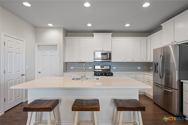 11820 Offaly Dr, Austin, TX 78754 - kitchen featuring appliances with stainless steel finishes, tasteful backsplash, a kitchen breakfast bar, dark wood-style floors, and recessed lighting