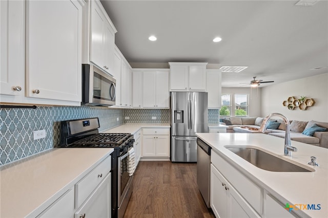 11820 Offaly Dr, Austin, TX 78754 - kitchen with appliances with stainless steel finishes, light countertops, dark wood-style floors, white cabinets, and recessed lighting