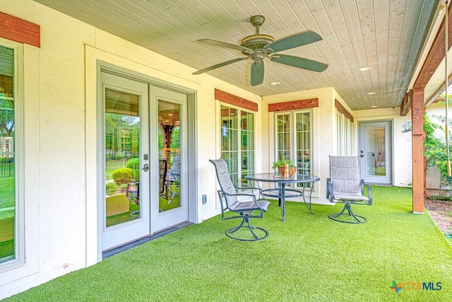 sunroom / solarium with a ceiling fan and french doors