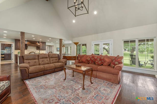 living room featuring dark wood-style flooring, high vaulted ceiling, a chandelier, and recessed lighting