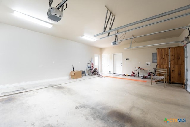 garage with a garage door opener and electric panel