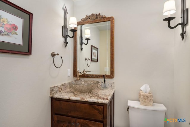 half bath featuring vanity and toilet