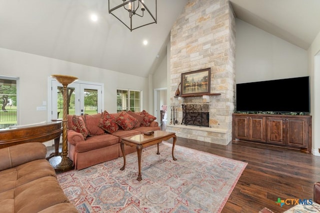 living area with dark wood-type flooring, a stone fireplace, high vaulted ceiling, and french doors