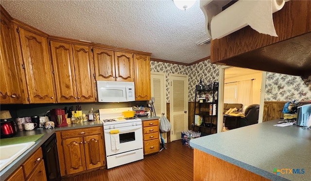 2405 Oak Dr, Gatesville, TX 76528 - kitchen with white appliances, wallpapered walls, a textured ceiling, brown cabinetry, and dark wood finished floors