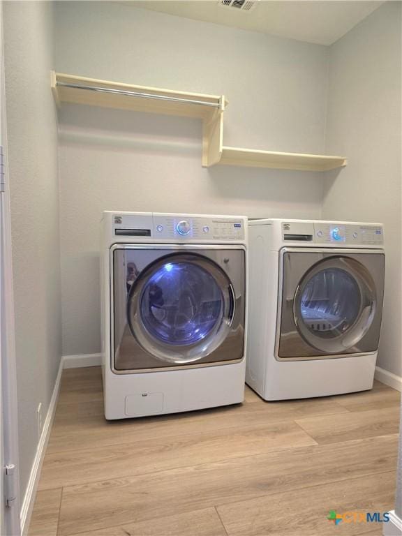 3300 Porter Creek Cv, Round Rock, TX 78665 - laundry area featuring washer and clothes dryer, laundry area, light wood-type flooring, visible vents, and baseboards