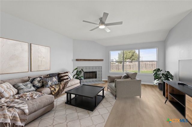 3300 Porter Creek Cv, Round Rock, TX 78665 - living area featuring a tiled fireplace, light wood-style floors, ceiling fan, baseboards, and lofted ceiling