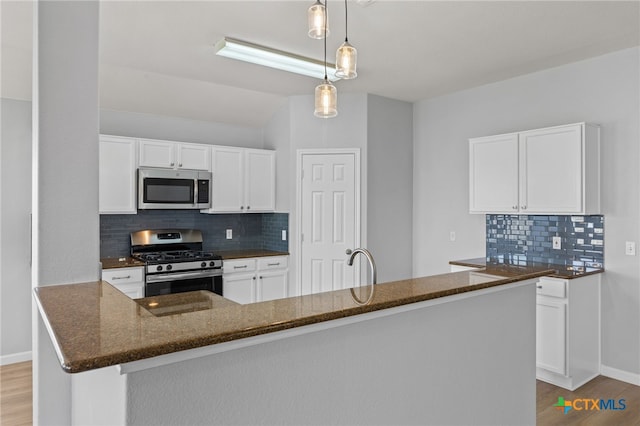 3300 Porter Creek Cv, Round Rock, TX 78665 - kitchen with appliances with stainless steel finishes, wood finished floors, decorative backsplash, and dark stone countertops