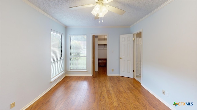 210 Londonderry Dr, Victoria, TX 77901 - unfurnished bedroom featuring a textured ceiling, wood finished floors, ornamental molding, a walk in closet, and a closet