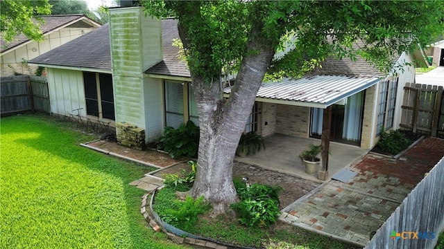 210 Londonderry Dr, Victoria, TX 77901 - rear view of house with a patio, a fenced backyard, a chimney, and a shingled roof