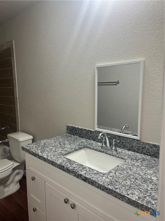 full bathroom with toilet, vanity, hardwood / wood-style floors, and shower / bathtub combination