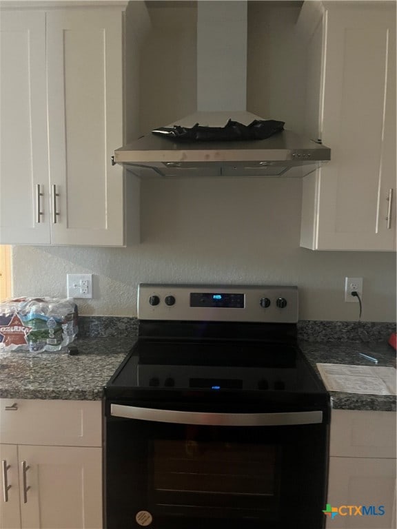 kitchen featuring white cabinetry, wall chimney exhaust hood, and stainless steel electric stove