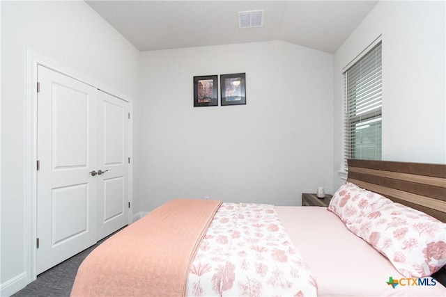 bedroom featuring lofted ceiling and dark colored carpet