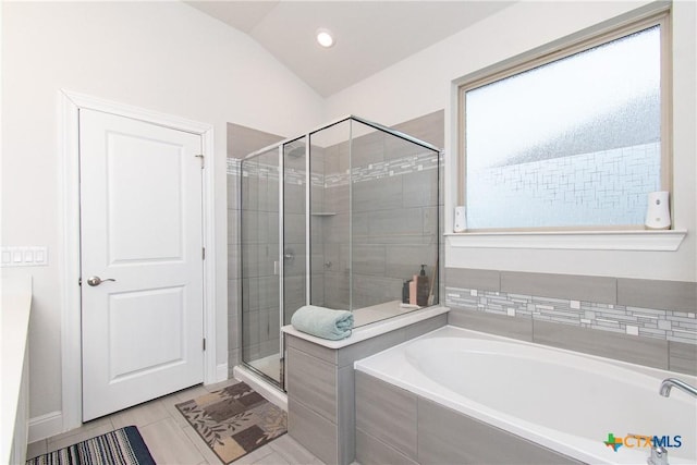 bathroom featuring independent shower and bath, lofted ceiling, and tile patterned floors