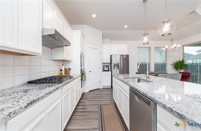 kitchen with sink, white cabinetry, hanging light fixtures, stainless steel appliances, and light stone countertops