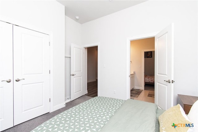 carpeted bedroom featuring ensuite bath and a closet