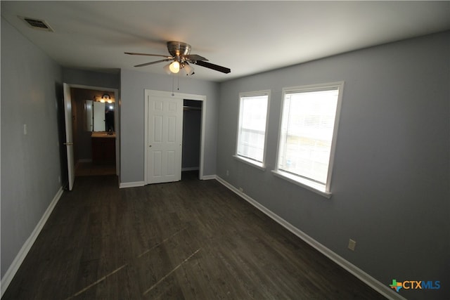 unfurnished bedroom with ceiling fan, dark hardwood / wood-style floors, a closet, and connected bathroom