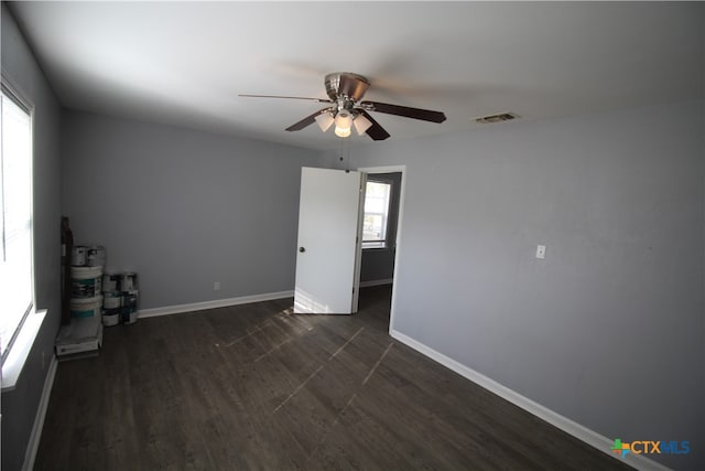 empty room with dark wood-type flooring and ceiling fan