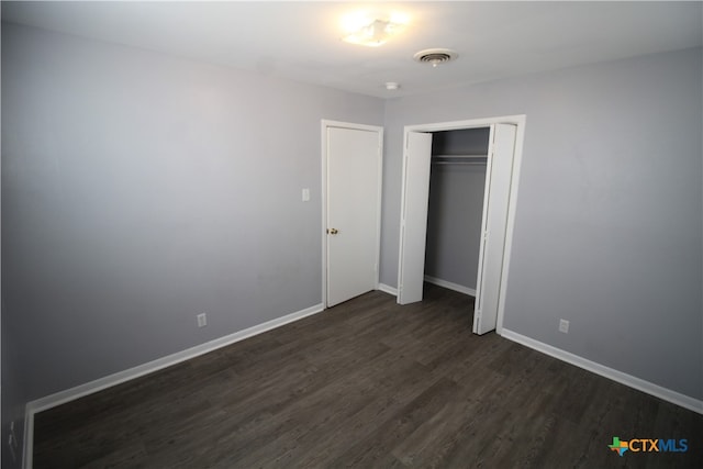 unfurnished bedroom featuring dark wood-type flooring and a closet